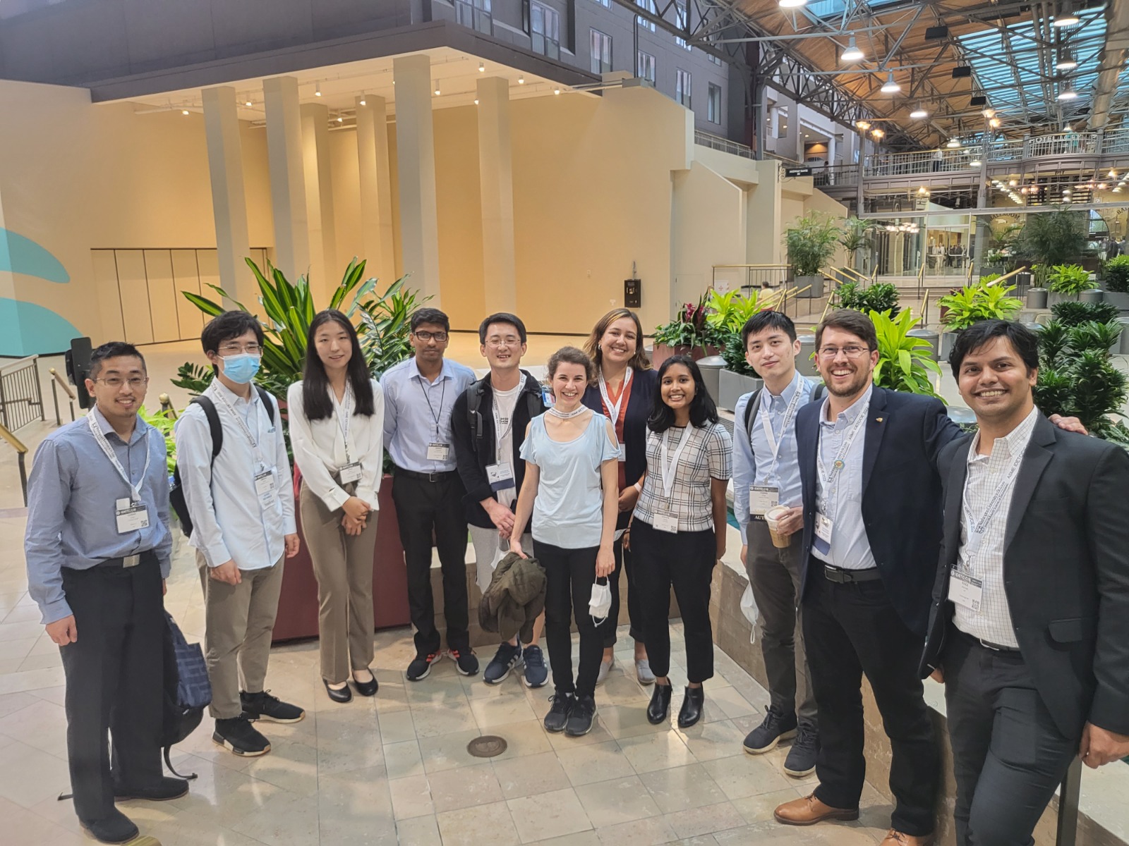 group of students in front of plants in conference hotel